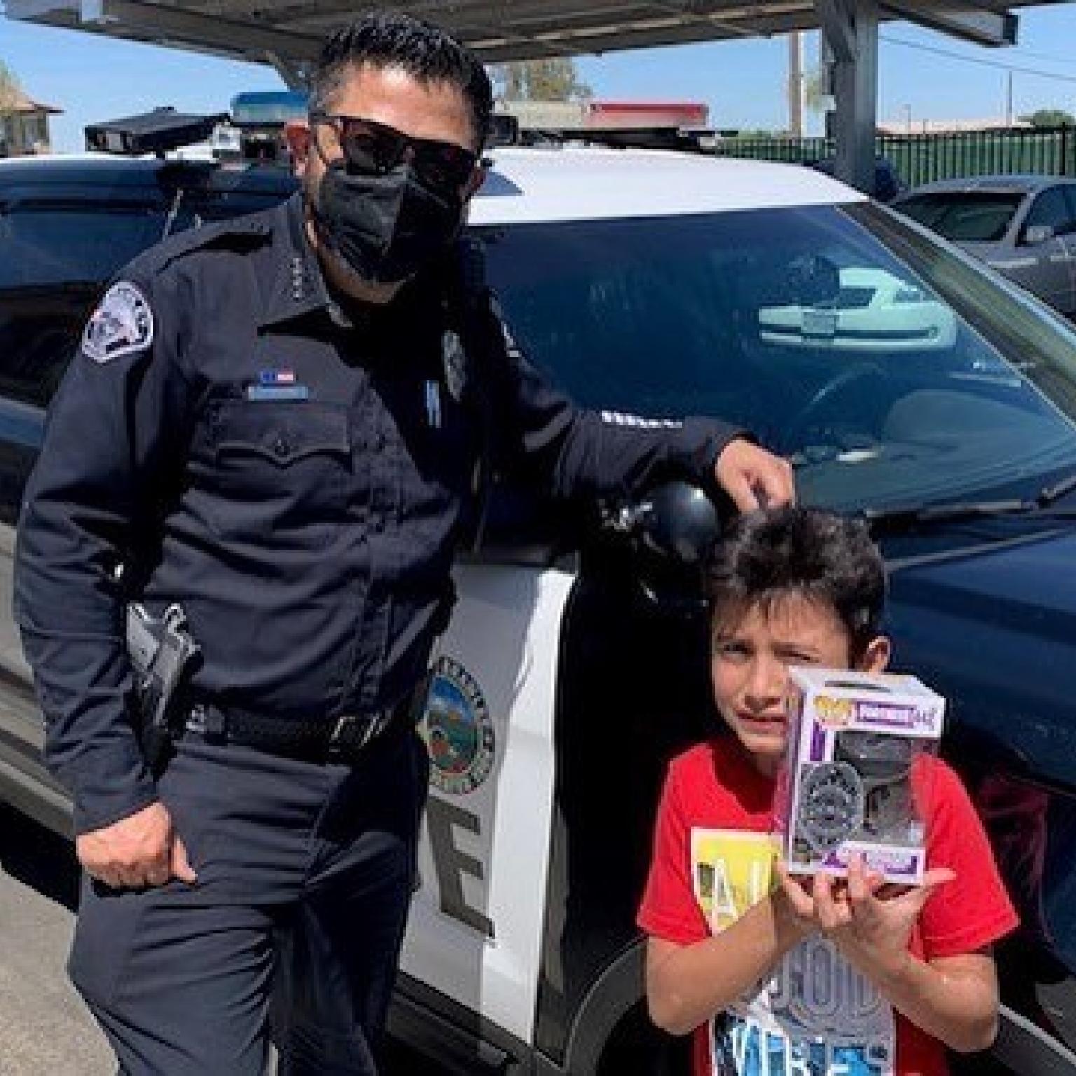 Brawley Police Officer and child holding Funko Police toy